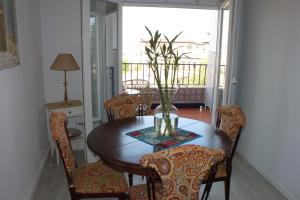 格拉纳达Apartamentos Vado - Cuesta de Alhacaba的餐桌、椅子和花瓶