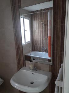 安特克拉Ático céntrico的浴室配有盥洗盆和浴缸。