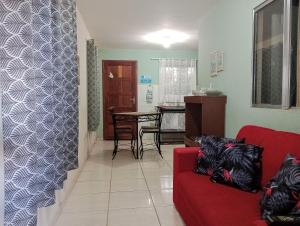 瓜拉派瑞Apt. de Setiba - HOSPEDARIA OCA RUCA的客厅配有红色的沙发和桌子