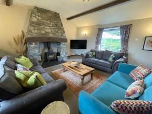 贝图瑟科伊德Orsedd Wen Cottage的带沙发和石制壁炉的客厅