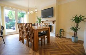 威勒尔5Bed House Wirral near Liverpool Chester的一间带木桌和椅子的用餐室
