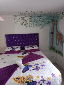 约翰内斯堡Love of Sixtus vanue hire and guest house的卧室配有一张壁挂长颈鹿壁画的床。