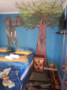 约翰内斯堡Love of Sixtus vanue hire and guest house的卧室里有一棵树和一头大象的壁画