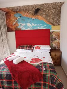 约翰内斯堡Love of Sixtus vanue hire and guest house的一间卧室配有一张红色床头板的床