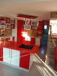 约翰内斯堡Love of Sixtus vanue hire and guest house的红色的厨房,配有白色的橱柜和红色的岛屿