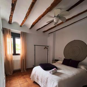 HinojaresCasa Rural Caballeriza的一间卧室配有一张床和吊扇