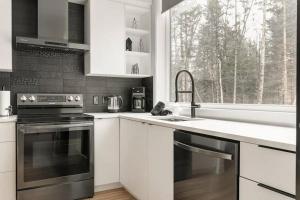 La ConceptionChalet Vintersaga Mont Tremblant的厨房配有白色橱柜、水槽和窗户。