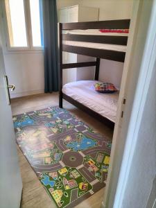 瓦尔拉普拉日Hôtel de la Mer的一间卧室配有双层床,地板上铺有火车地毯
