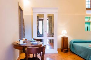 梅塔YourHome - Casa Cafiero的客房设有桌子、床、床、桌子和椅子。