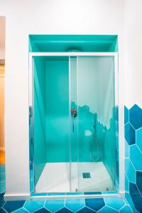 梅塔YourHome - Casa Cafiero的浴室设有玻璃淋浴间,铺有蓝色瓷砖