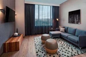 圣何塞AC Hotel by Marriott San Jose Escazu的客厅配有蓝色的沙发和电视