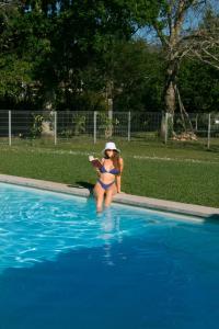 巴伦西亚Quinta do Caminho, AL的坐在游泳池里的比基尼女人