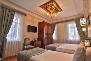 伊斯坦布尔Blue House Hotel Old City - Sultanahmet的酒店客房设有两张床和吊灯。