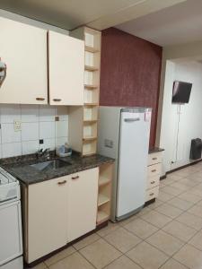 门多萨Departamentos Romano的厨房配有白色橱柜和白色冰箱。