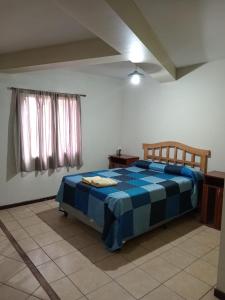 门多萨Departamentos Romano的一间位于客房内的卧室,配有蓝色和白色的床