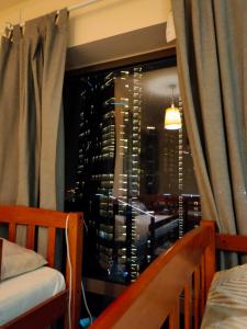 迪拜Bohemian Backpackers的一间卧室设有窗户,享有城市美景