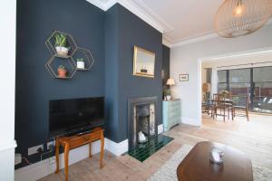 滨海绍森德Pass the Keys Cosy Stylish house near Southend的客厅设有带壁炉的蓝色墙壁