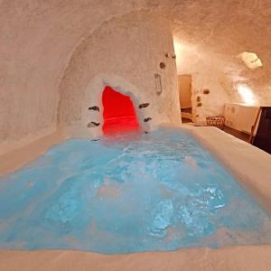 LE GRAND LOGIS, chambre Santorin avec spa privatif的带壁炉的客房内的蓝色大泳池