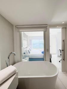 里约热内卢CDesign Hotel的配有床铺的客房内的白色浴缸