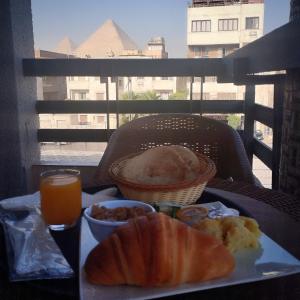 开罗Zahira Pyramids View的一张桌子,上面放着一盘食物和一杯橙汁