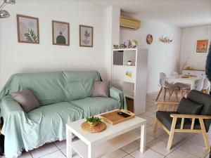 格吕桑Fleur De Sel的客厅配有绿色沙发和桌子