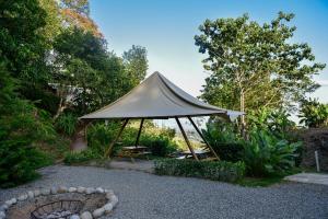 PacuarQuimera Glamping的花园内的帐篷,配有长凳和桌子