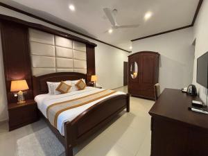 康提Serenity Villa Digana的一间卧室配有一张床、梳妆台和电视。