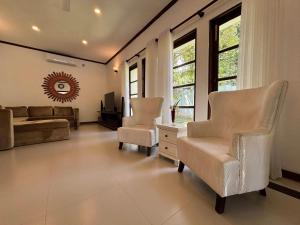 康提Serenity Villa Digana的客厅配有两把椅子和一张沙发