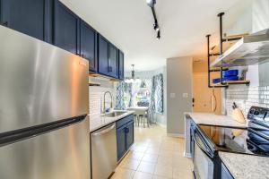 杰克逊维尔Charming Jacksonville Abode with Patio!的厨房配有蓝色橱柜和不锈钢冰箱