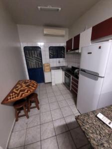 博阿维斯塔Apartamento em Jardim Floresta的厨房配有桌子和白色冰箱。