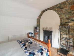 Curragh Cottage的一间卧室配有一张床和一个壁炉