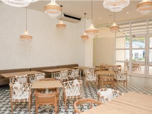科韦尼亚斯Ciela Hotel & Beach Club的用餐室配有桌椅和吊灯。