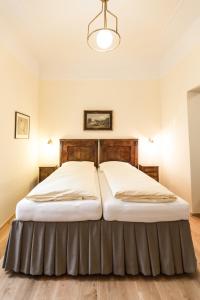 巴特格莱兴贝格Villa Thalhof的一间卧室配有一张大床和木制床头板