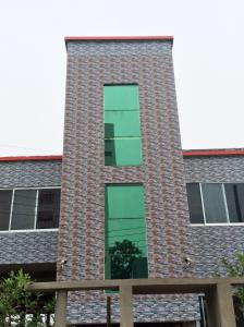 巴纳内拉斯ApartmenT - Homestays的一座高大的砖砌建筑,设有绿色的窗户