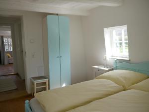 Wallenstedt布鲁特斯赫霍夫公寓的一间卧室设有一张床、一个窗口和一面镜子