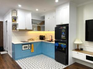 海防Dino Home Hilton Luxury的厨房配有蓝色橱柜和黑色冰箱。