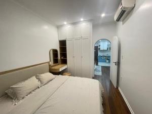 海防Dino Home Hilton Luxury的一间白色卧室,配有一张床和一个走廊