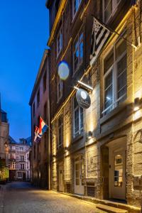 圣马洛Hôtel Le Nautilus的街道上挂着旗帜的建筑