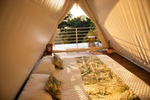 PacuarQuimera Glamping的帐篷内带床的房间,设有窗户