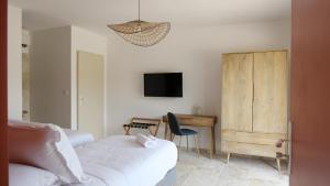 OlmicciaA Machja的一间卧室配有一张床、一张书桌和一台电视。
