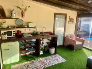 贝纳尔马德纳Bungalow Aloha con Piscina Privada y Barbacoa的厨房配有带微波炉的桌子和绿色地毯