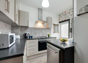 泰恩河畔纽卡斯尔Newcastle CITY Apartments 5的厨房配有微波炉和炉灶。 顶部烤箱