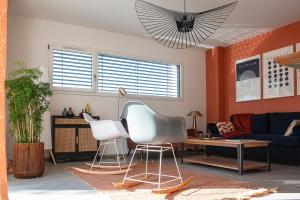 于南格Villa Claber的客厅设有橙色墙壁和白色椅子
