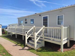 托基Torbay Holiday Home at The Waterside Holiday Park - With Deck and Sea View的移动房屋设有白色栏杆和楼梯