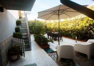 布拉加Maria Home Reall's的庭院配有遮阳伞和桌椅。