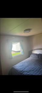 格兰奇奥沃桑茨Caravan At Haven Lakeland的一间卧室设有一张床和一个窗口