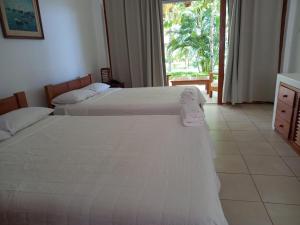 索里托斯Bungalows & Suites Punta Camarón的配有窗户的酒店客房内的两张床