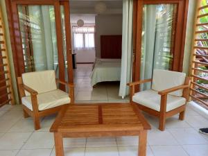 索里托斯Bungalows & Suites Punta Camarón的一间设有两把椅子、一张桌子和一张床的房间