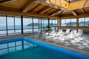 蒙特港abba Presidente Suites Puerto Montt的客房设有游泳池、椅子和桌子。