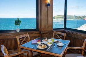 蒙特港abba Presidente Suites Puerto Montt的一张带食物的桌子,享有海景